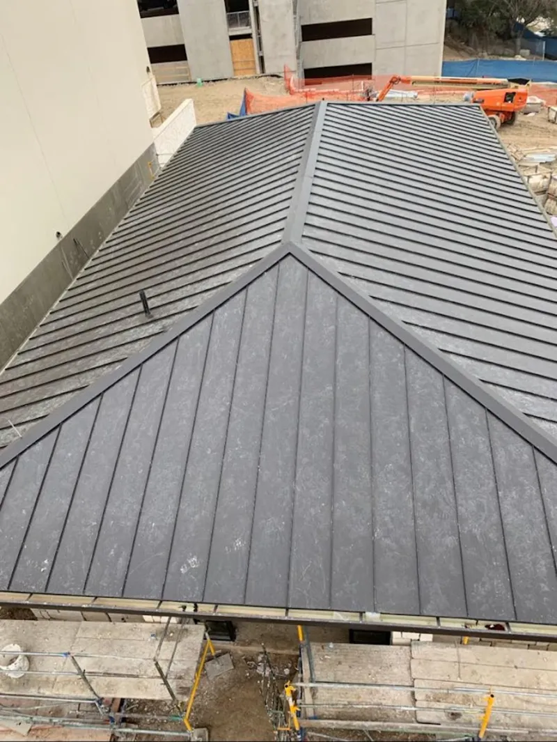 Commercial metal roof construction with crane equipment in Spokane Valley